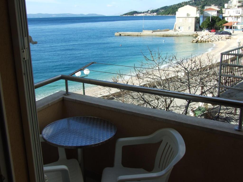 a balcony with a table and chairs and a view of the ocean at Apartmani ''Srečko'' Drašnice in Drasnice