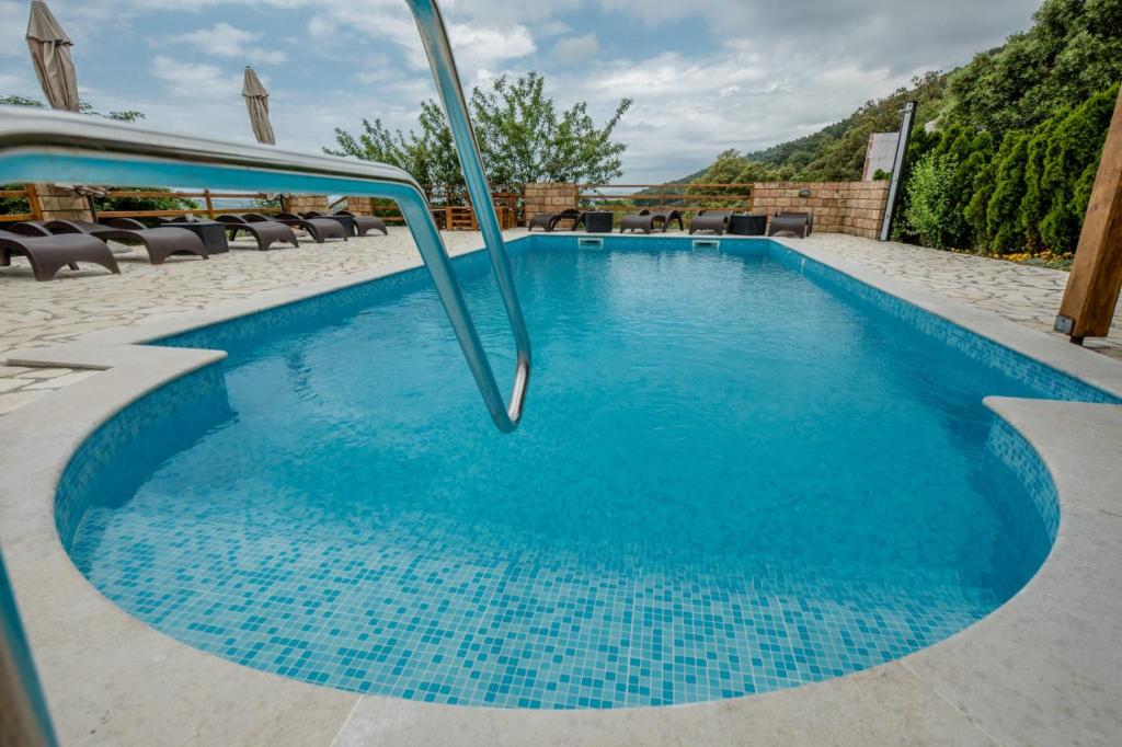 a blue swimming pool with blue tiles on the ground at Apartment in Mundanije with Seaview, Terrace, Air condition, WIFI (3748-2) in Mundanije