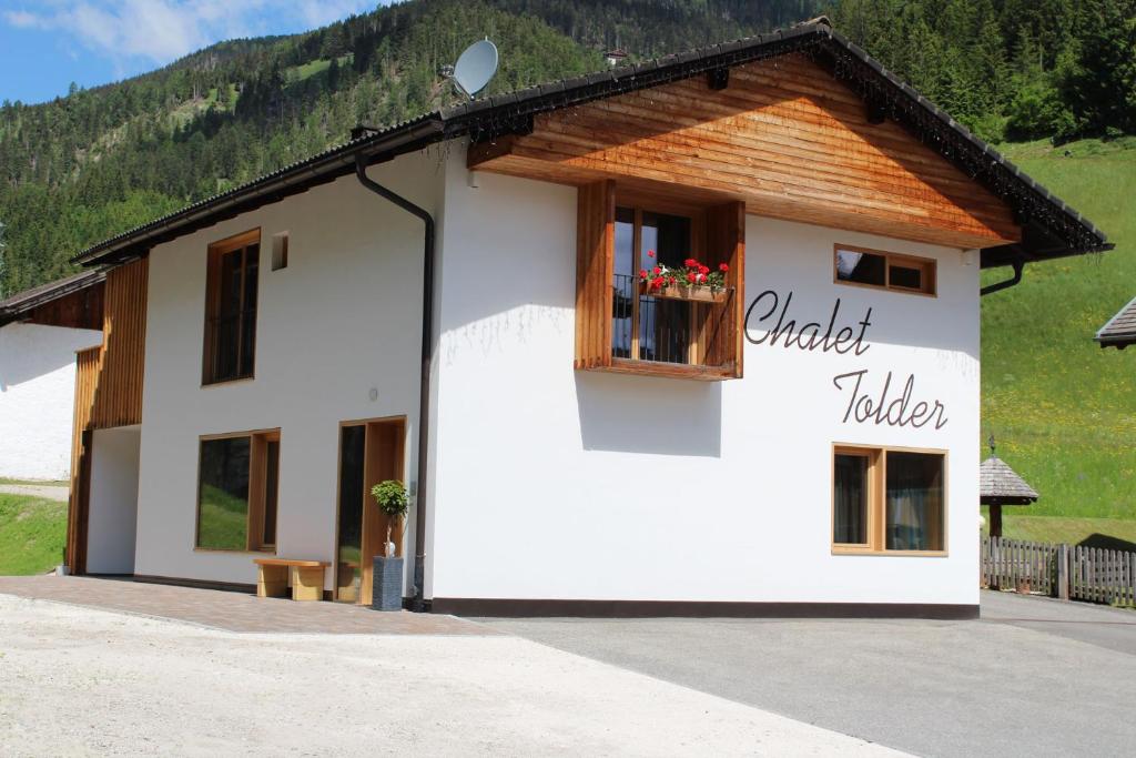 a small white building with a wooden roof at Chalet Tolder in San Candido