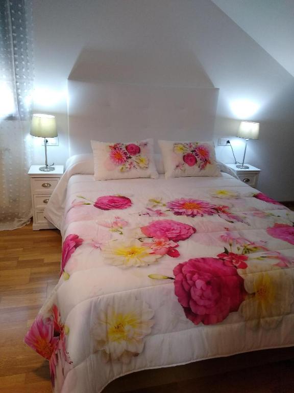 a bedroom with a bed with flowers on it at En plena Ribera Sacra CasaCocó in Ferreira