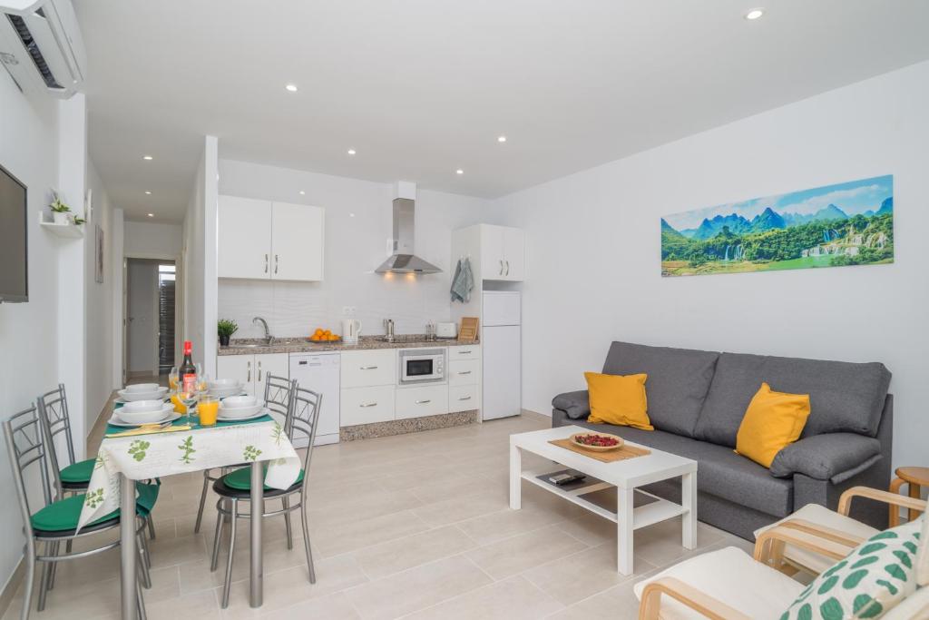 een woonkamer en een keuken met een bank en een tafel bij Aire Siroco - Beach Apartment 14 in Benalmádena