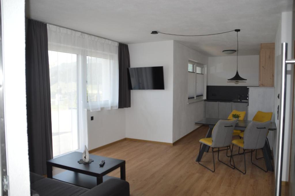 salon ze stołem i żółtymi krzesłami w obiekcie Apart Bergsonne w mieście Fiss