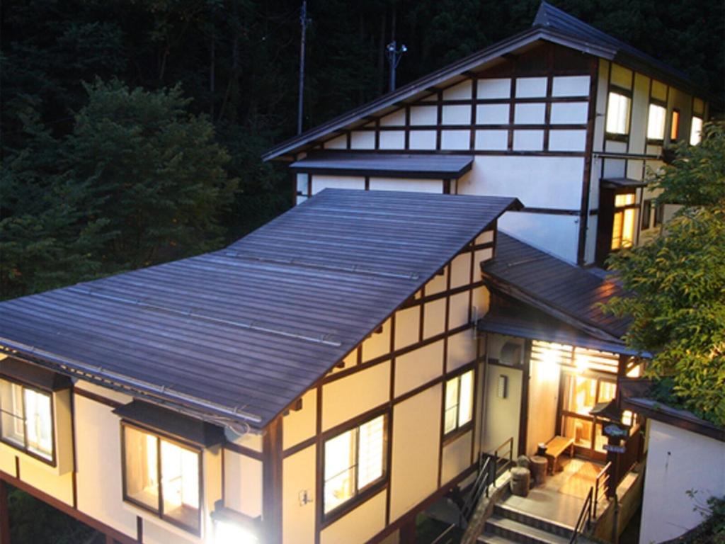 - une vue sur l'extérieur de la maison la nuit dans l'établissement Oyado Fubuki, à Nozawa Onsen