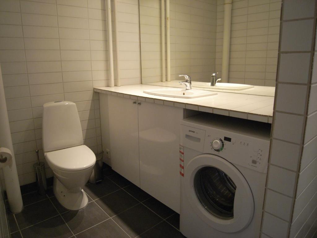 a bathroom with a washing machine and a sink at Nyborggade in Copenhagen