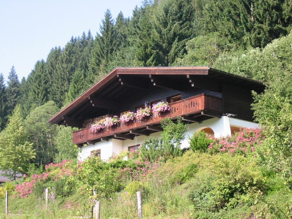a house with a balcony with flowers on it at Ferienwohnung Hans Ebner in Eben im Pongau