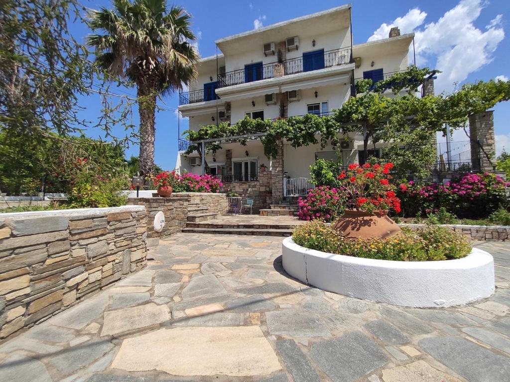 a large white building with flowers in a courtyard at Armeno Studios in Limenaria