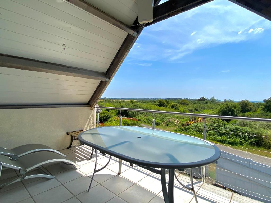 une table en verre sur le balcon d'une maison dans l'établissement REF 008 Maison T2 à Tumiac entre Océan et Golfe du Morbihan, à Arzon