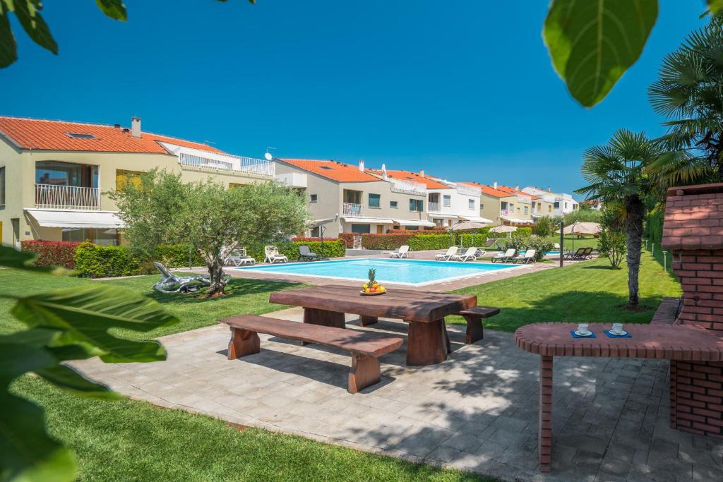 a picnic table and bench next to a swimming pool at Maj Premium Residence in Poreč