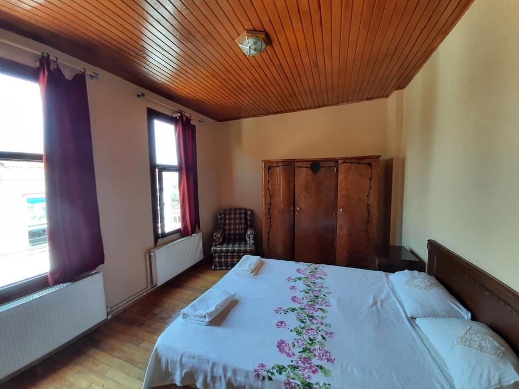 a bedroom with a bed with a white bedspread with flowers on it at Manzaraada Merkez in Heybeliada