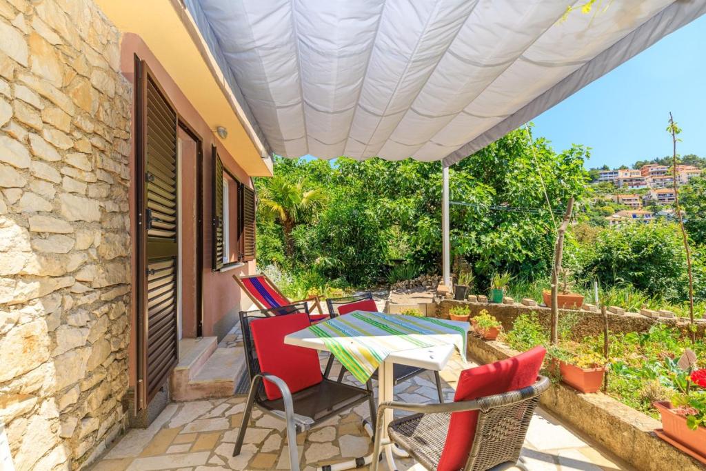 a patio with a table and chairs under a roof at Apartments Vivijana in Rabac