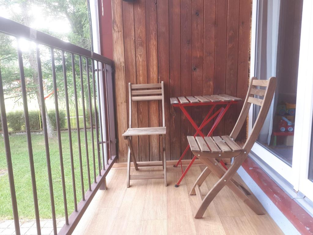 a porch with two chairs and a desk on a balcony at Apartmán Spa Šumava in Zdíkov