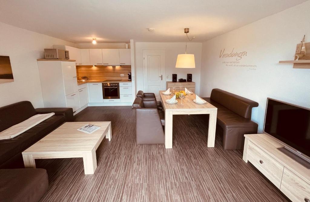 un salon avec un canapé, une table et une télévision dans l'établissement Appartement yoursylt.two, à Westerland