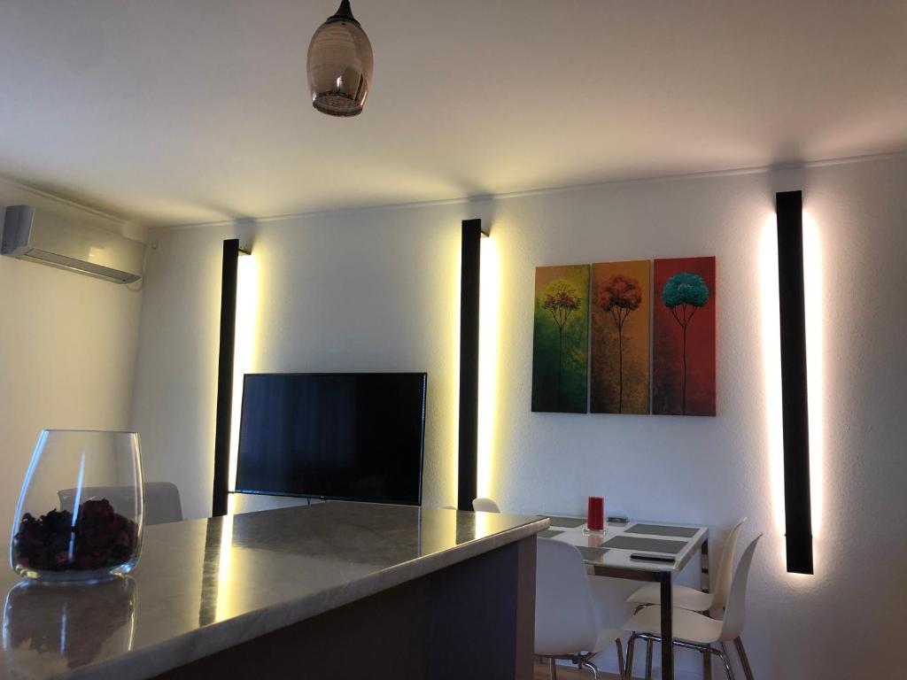 a living room with a counter with a table and a television at Hanga Apartman in Tiszafüred