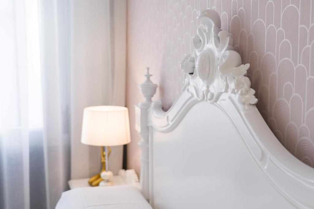 um quarto com uma cama branca e um candeeiro em PENSIÓN FERRADURA em Melide