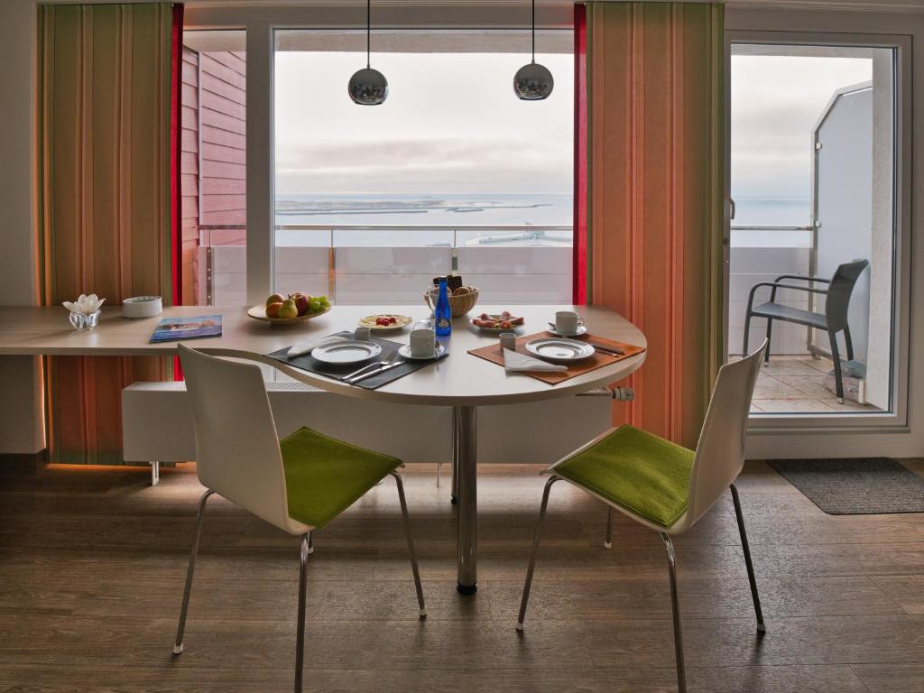 a table and chairs in a room with a window at Apartmenthaus Hohenfels in Helgoland
