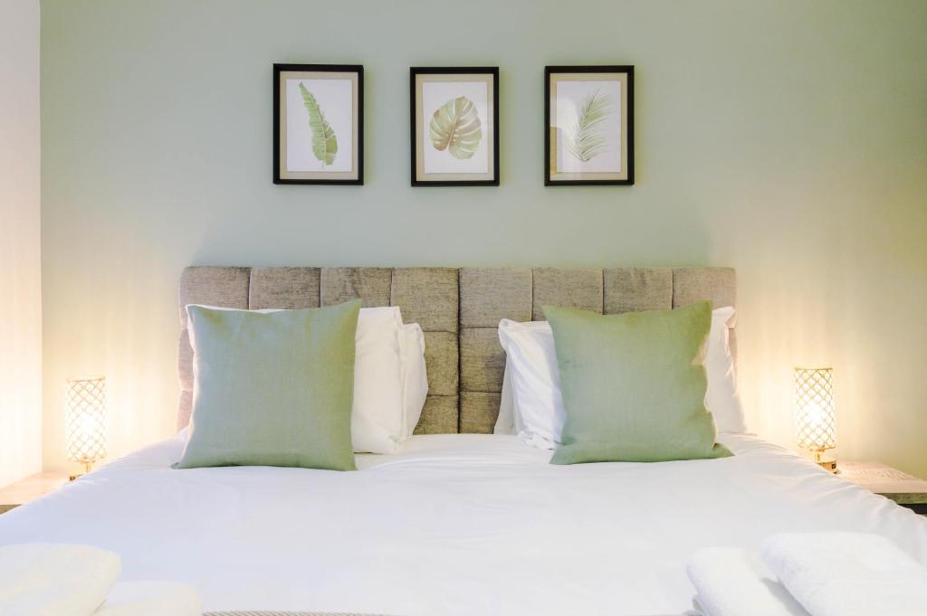 sypialnia z białym łóżkiem z 3 obrazami na ścianie w obiekcie Lightfoot House w mieście Chester