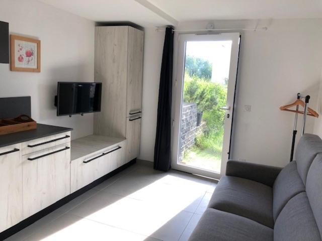 uma sala de estar com um sofá e uma grande janela em LE BEL AIR em Pugny-Chatenod