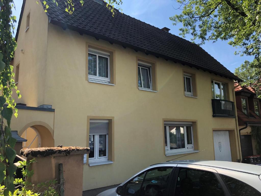 ein gelbes Haus mit einem davor geparkt in der Unterkunft Ferienhaus Gonsbach in Mainz