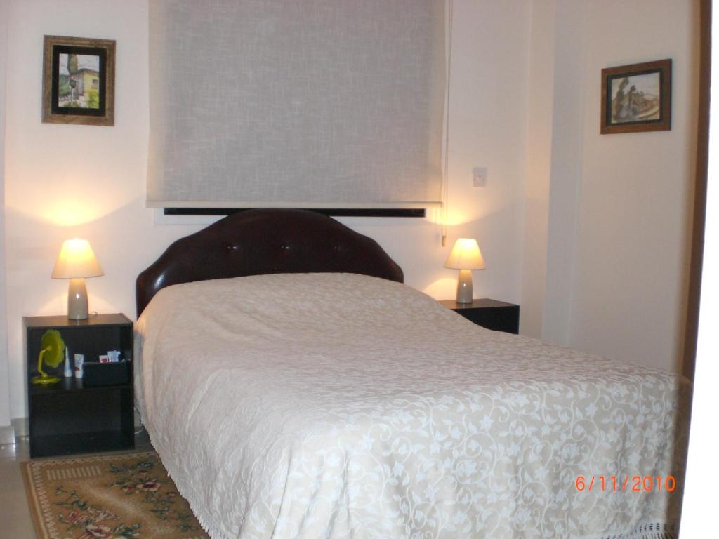 a bedroom with a bed and two lamps on tables at St. Lazaros Seaside Apartment in Larnaka