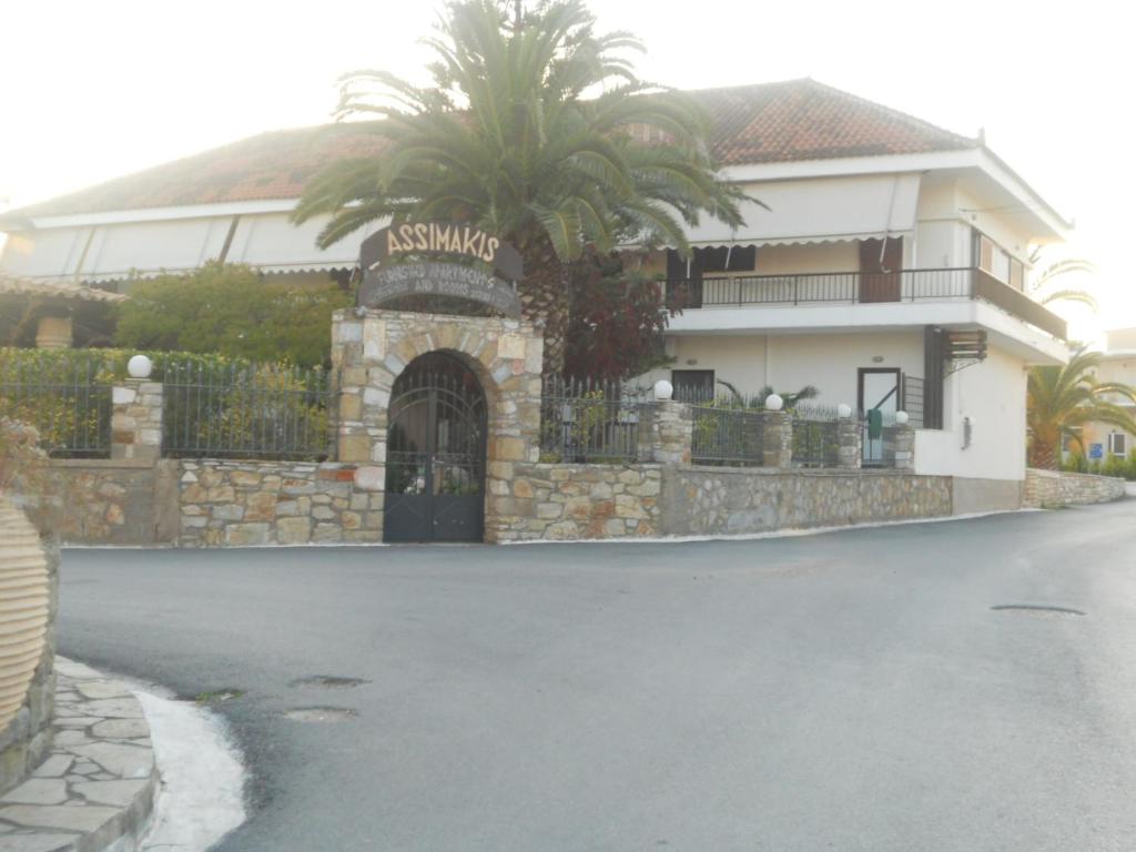 una casa con una palmera frente a una entrada en Assimakis Hotel, en Finikounta