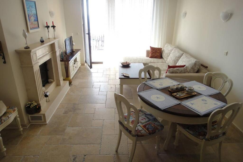 uma sala de estar com uma mesa e uma lareira em La Casa del Mar Kaliakria - Стилен апартамент в Калиакрия Резорт em Topola
