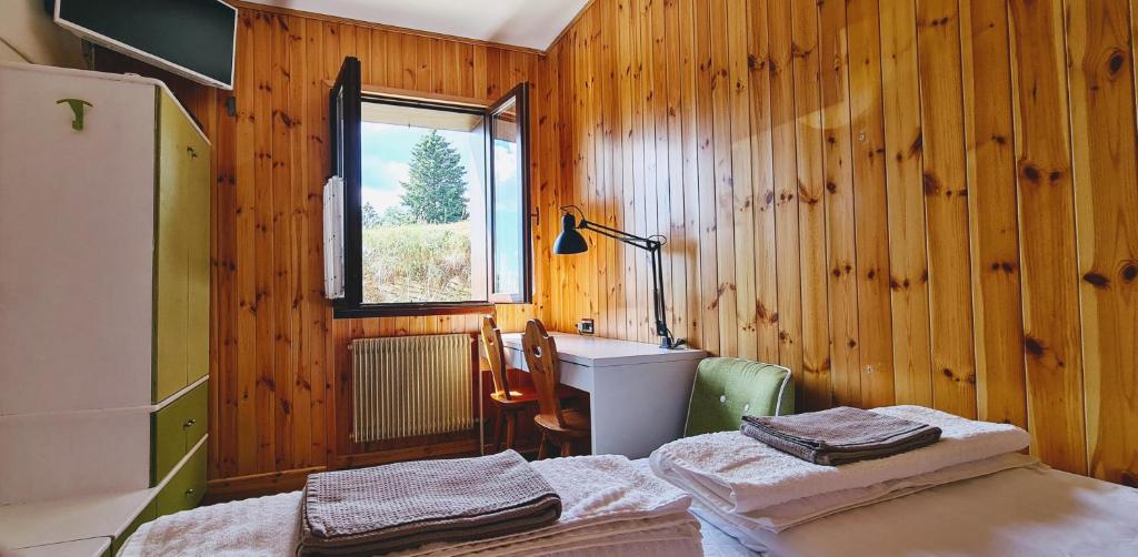 a room with two beds and a sink and a window at Oseli22 in Lavarone