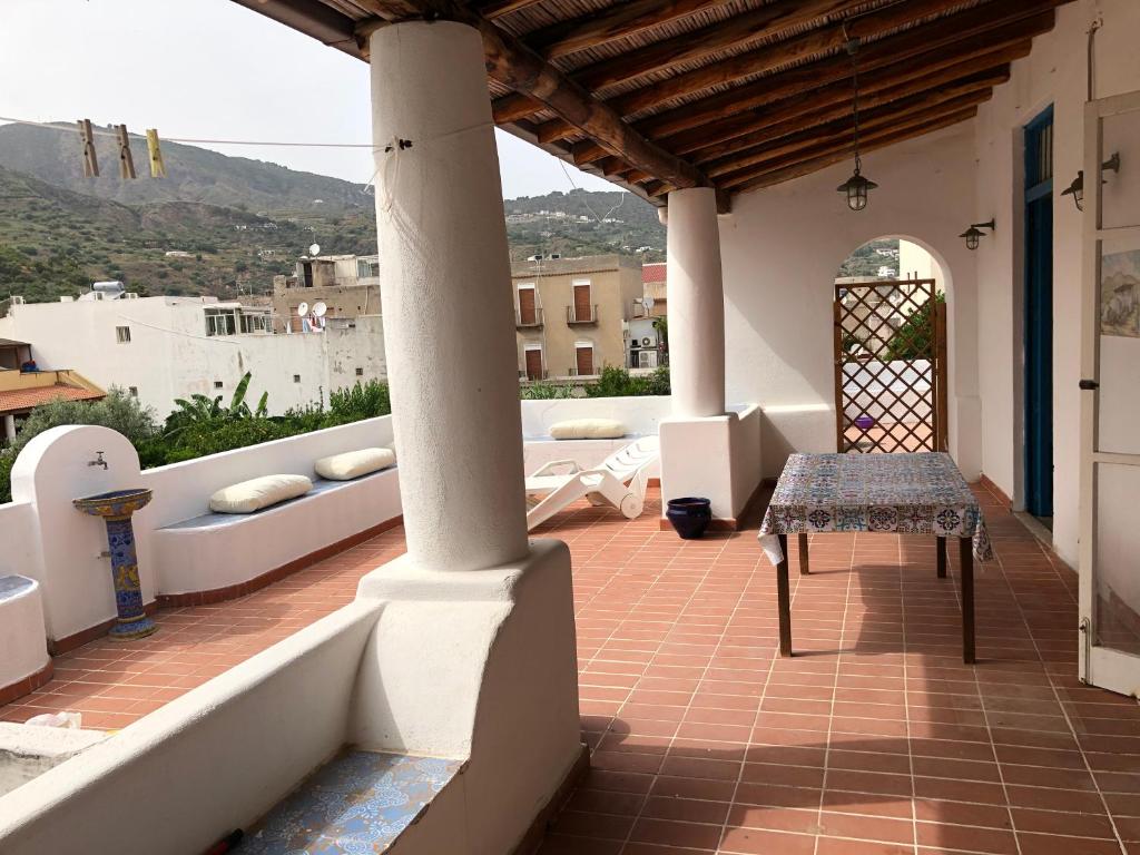 - une terrasse avec une table et un banc dans un bâtiment dans l'établissement Isola - LIPARI centro storico, à Lipari