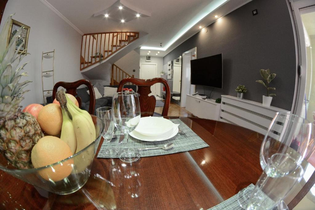 a dining room table with a bowl of fruit on it at Apartment DobraYa Blue in Novi Sad