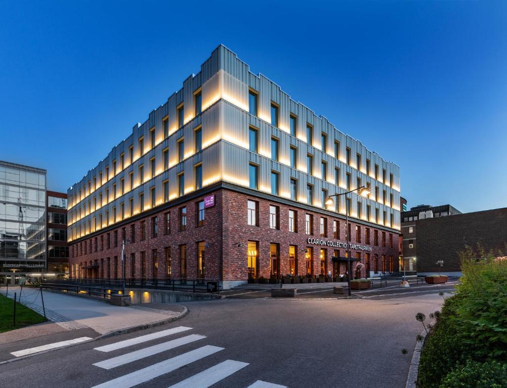 a large building in a city with a street at Clarion Collection Hotel Tapetfabriken in Stockholm