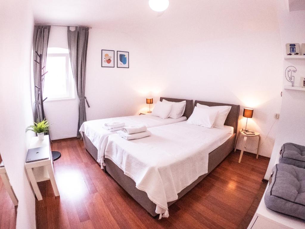 1 dormitorio con 1 cama grande con sábanas blancas en Pinna Apartments Hvar, en Hvar
