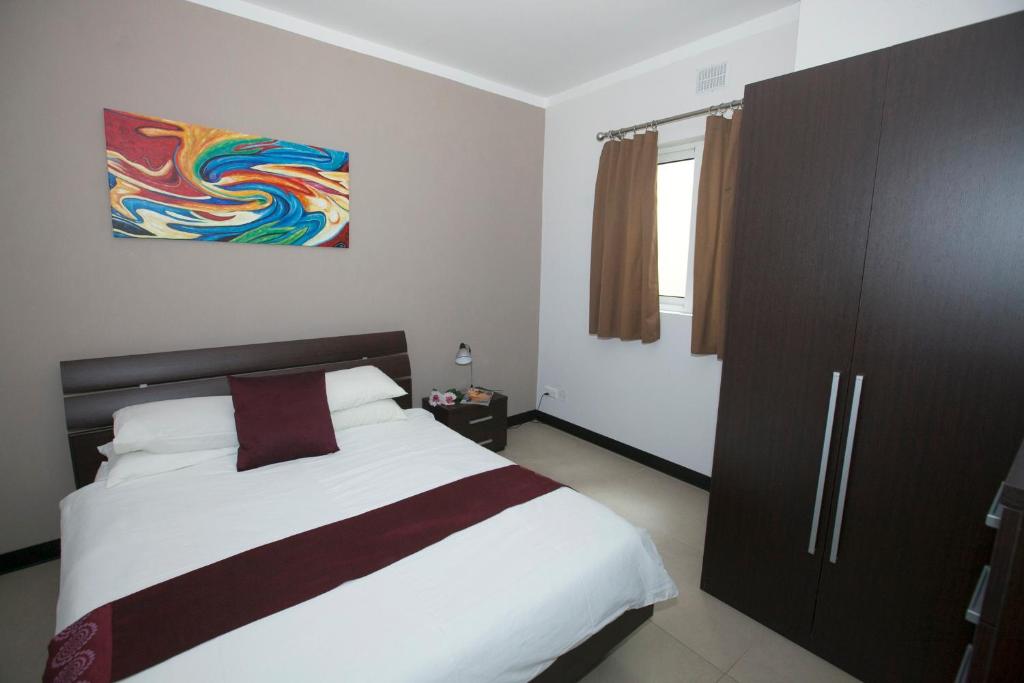 1 dormitorio con 1 cama y una pintura en la pared en Best Of Xlendi SeaFront Apartments, en Xlendi