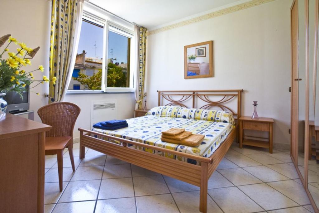 索伦托Villa Francesca Sorrento的一间卧室，里面有一张床、一张桌子和一扇窗户