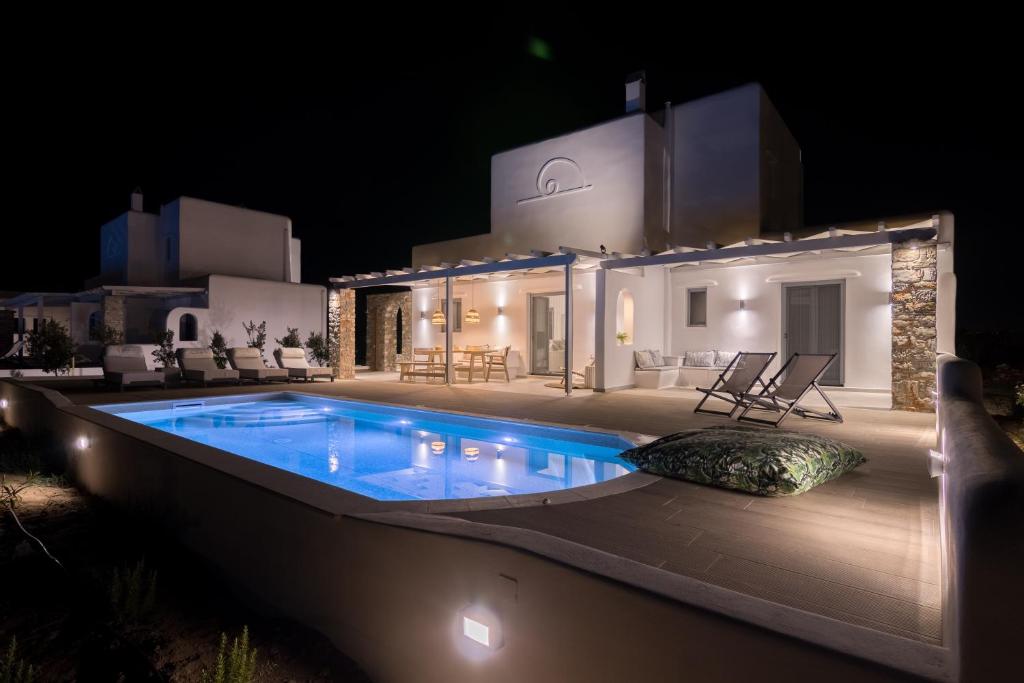 a villa with a swimming pool at night at Isalos Villas with private pool in Naxos Chora