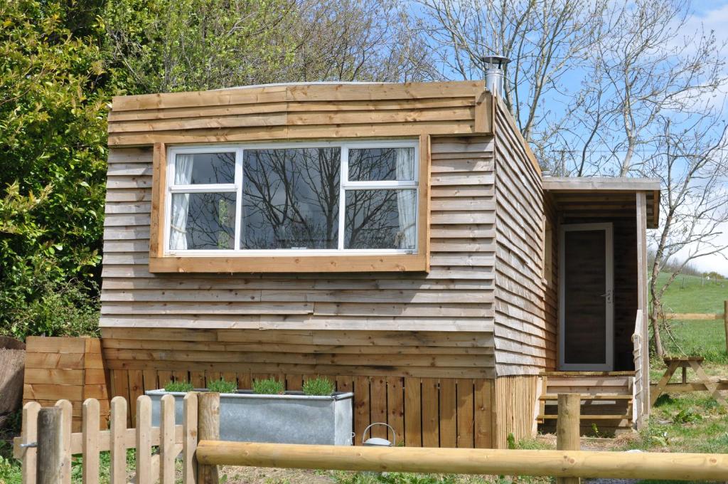 een tiny house met een raam en een hek bij Cosy and rural Lodge at Goldhill Glamping in Shaftesbury
