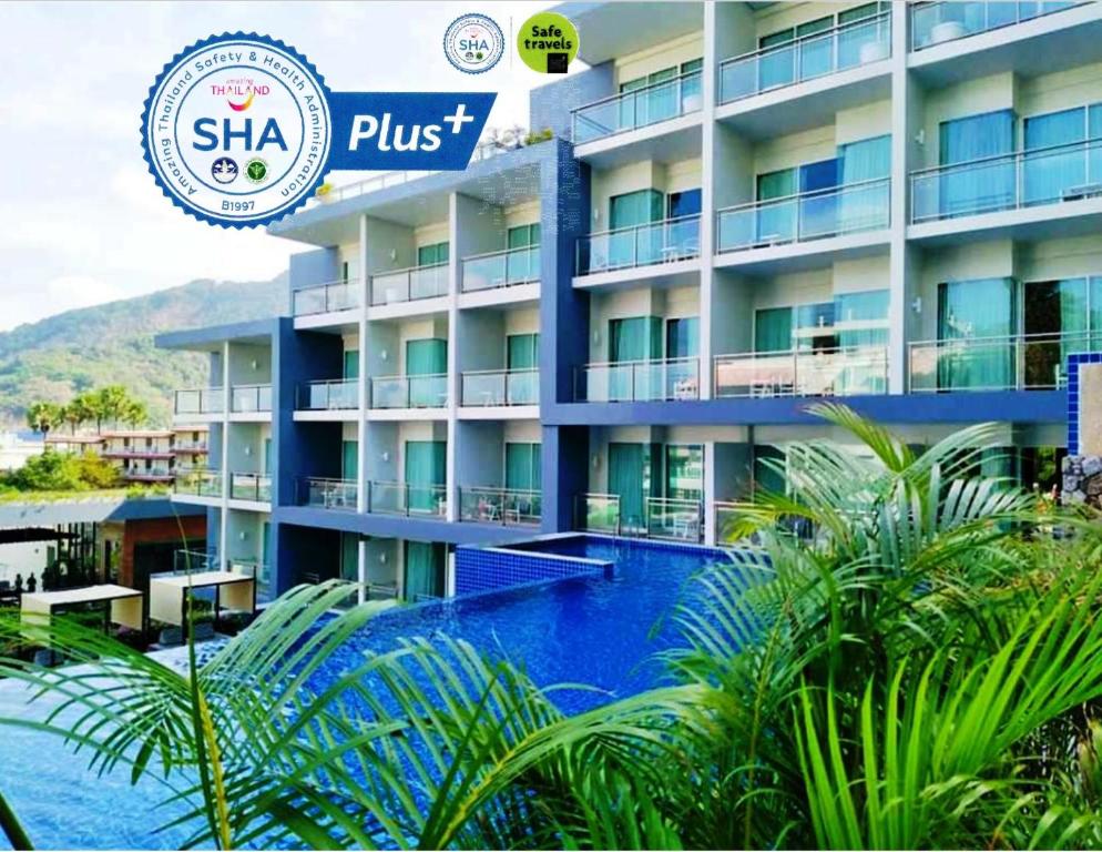 a hotel with a swimming pool in front of a building at Sugar Palm Grand Hillside - SHA Plus in Kata Beach