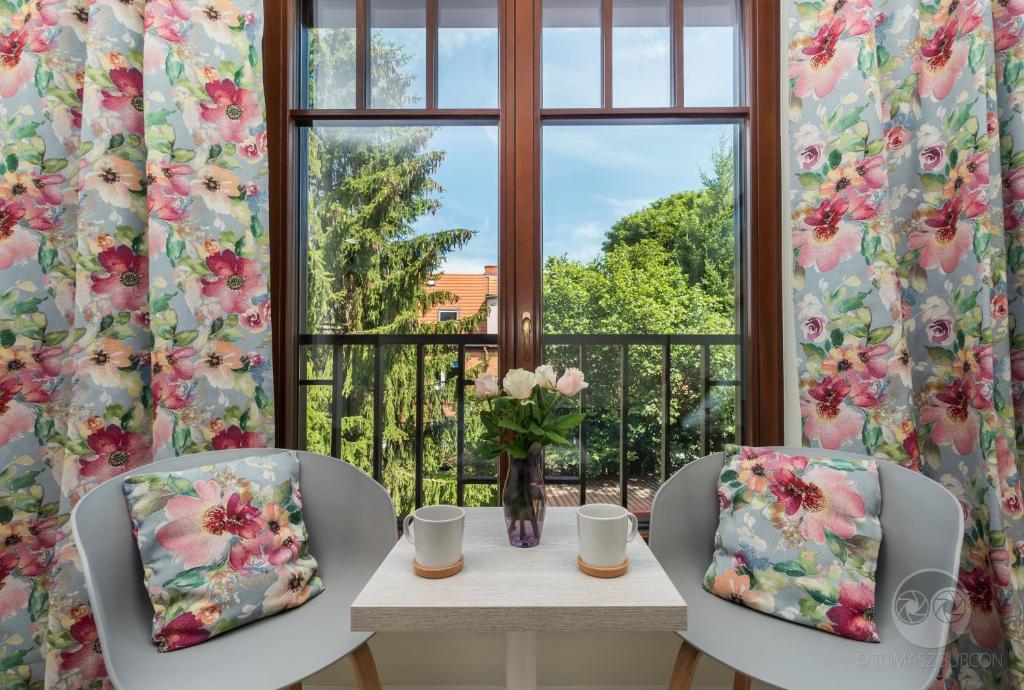um quarto com uma mesa e duas cadeiras e uma janela em Zamorski BY THE SEA em Sopot
