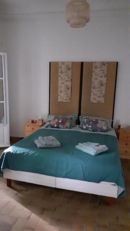 - une chambre avec un lit vert et 2 serviettes dans l'établissement SENTIMIR, à Saint-Génis