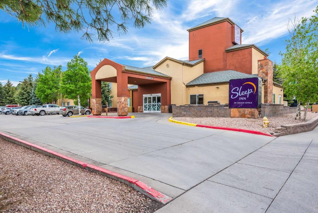 um edifício com uma placa em frente a um parque de estacionamento em Sleep Inn Flagstaff em Flagstaff