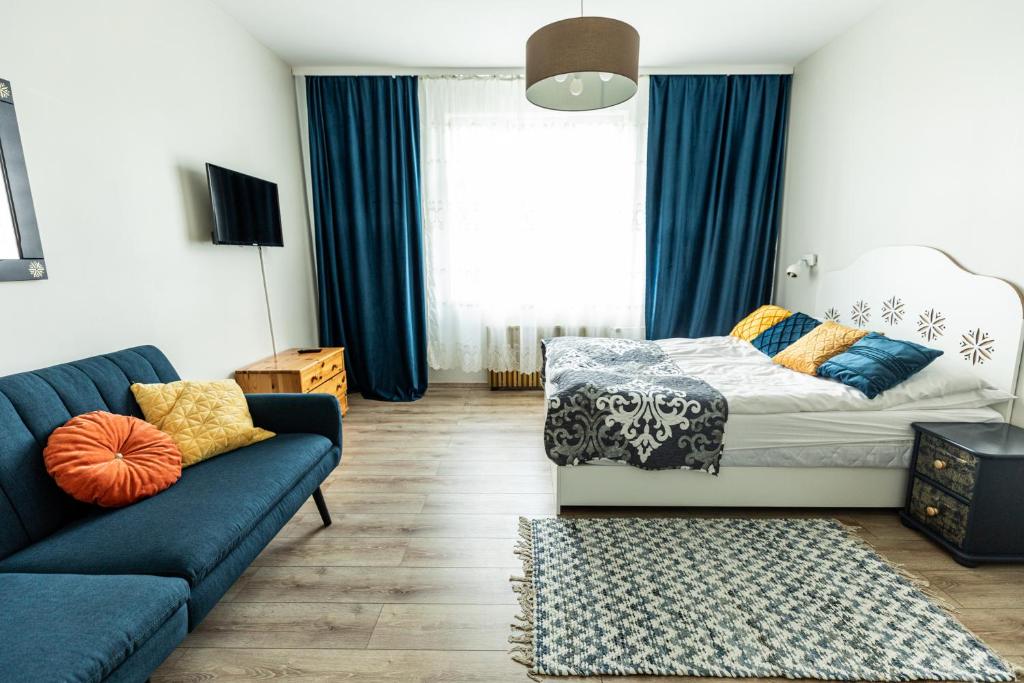 a living room with a couch and a bed at Willa Halinówka in Krynica Zdrój