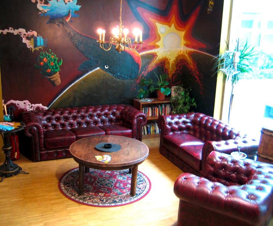 ベルリンにあるハート オブ ゴールドホステル ベルリンのリビングルーム(革張りのソファ、テーブル付)