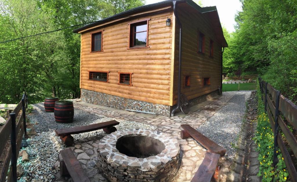 una cabaña de madera con una hoguera en el patio en Chata Sklene Teplice en Sklené Teplice