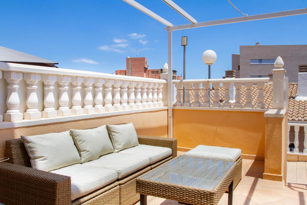 een patio met een bank en een tafel op een balkon bij Myflats Premium Mirador in Arenales del Sol