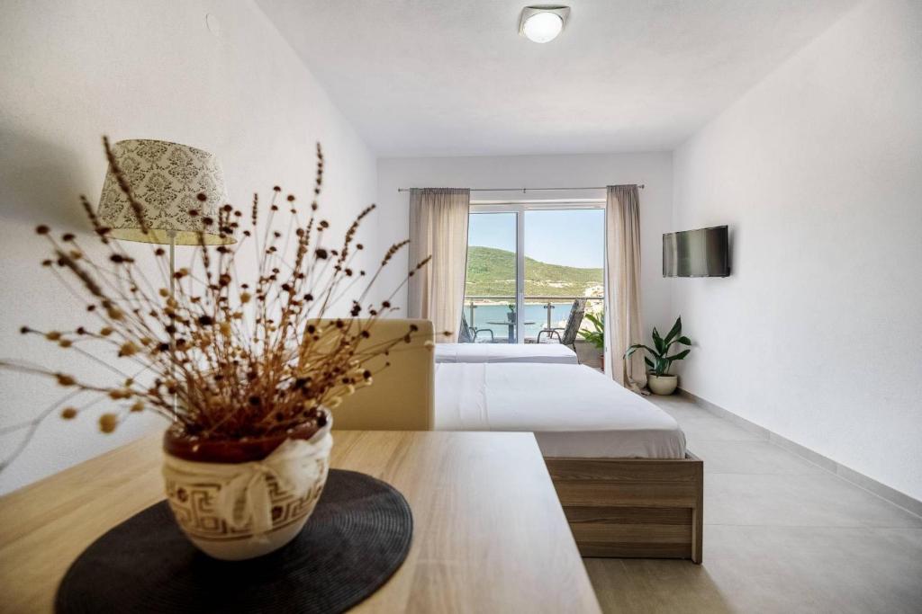 a bedroom with a bed and a vase on a table at Apartmani Divna in Neum