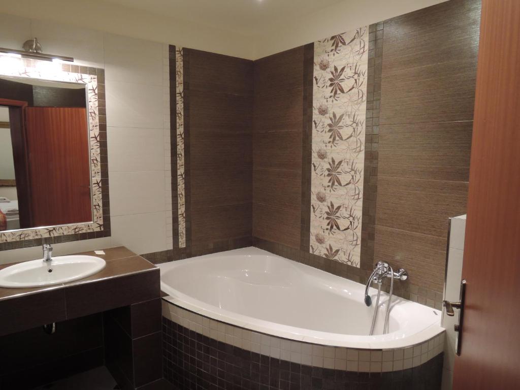 a bathroom with a bath tub and a sink at Penzion U Císaře Zikmunda in Znojmo