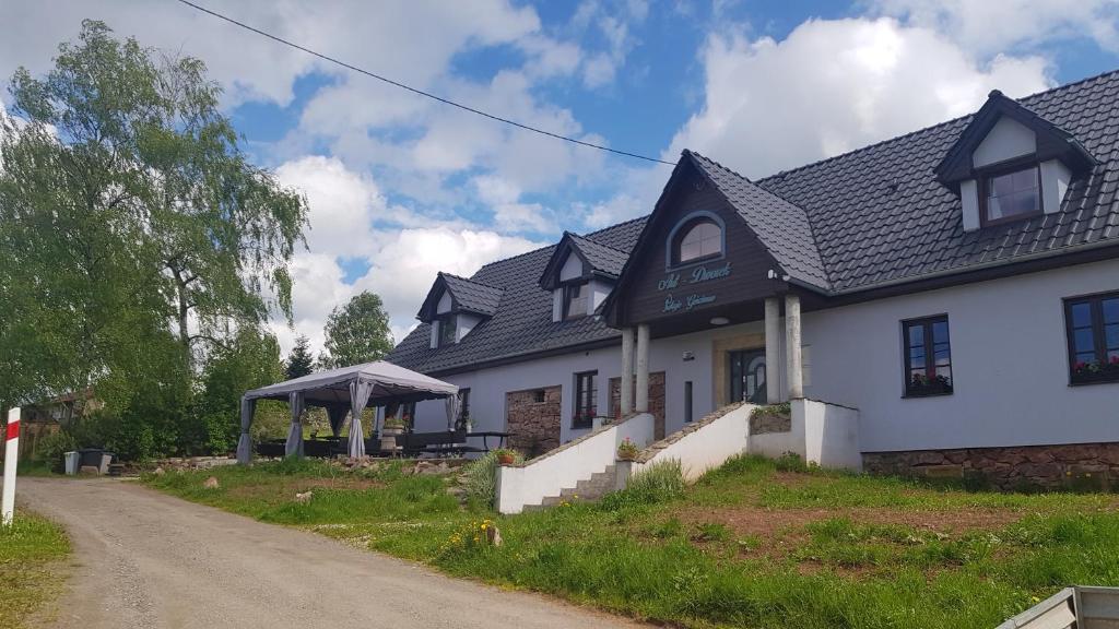 una casa blanca con un cenador en un camino de tierra en Pokoje Gościnne Art- Dworek, en Kudowa-Zdrój