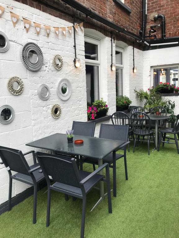 a patio with tables and chairs on the grass at The Wellington House Hotel in Blackpool