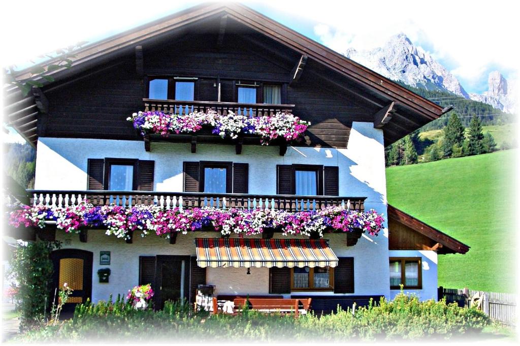 a house with flowers on the balconies of it at Haus Hartl in Saalfelden am Steinernen Meer