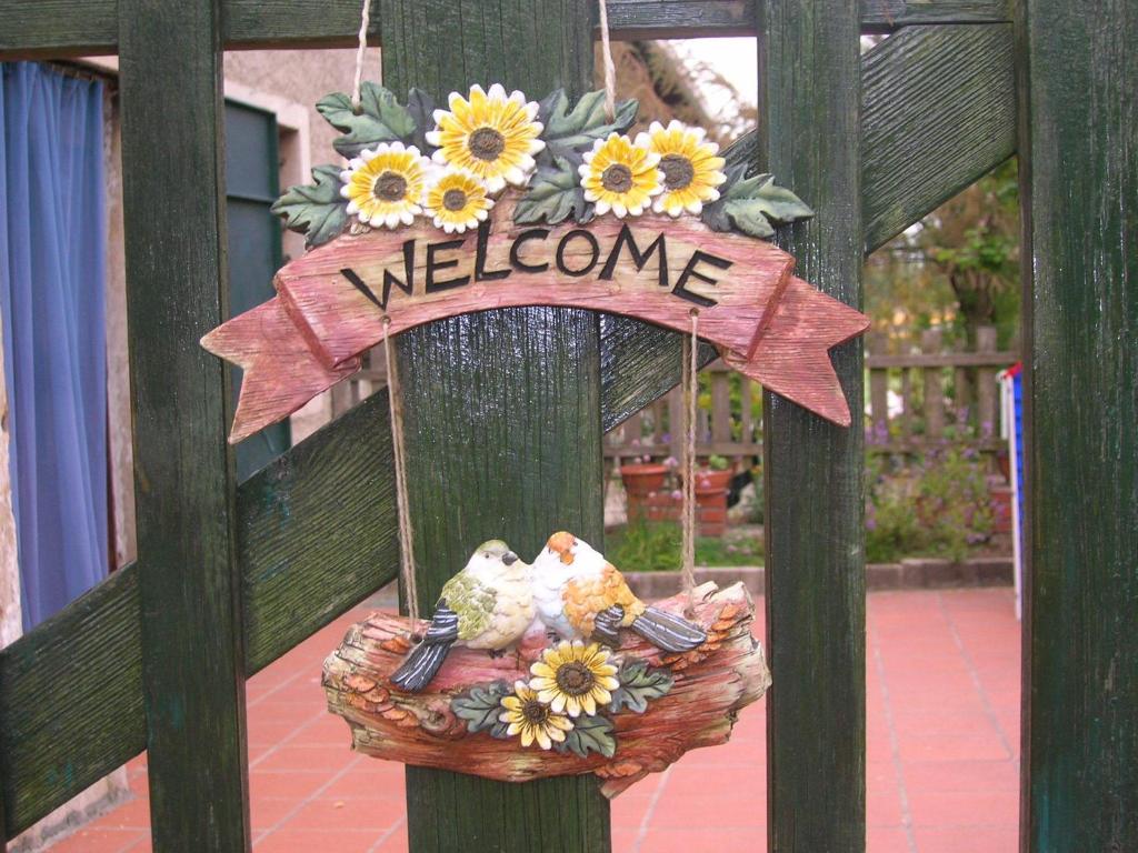 una señal de bienvenida en una valla con una cesta de flores en I Vigneti Bed & Breakfast, en Salionze