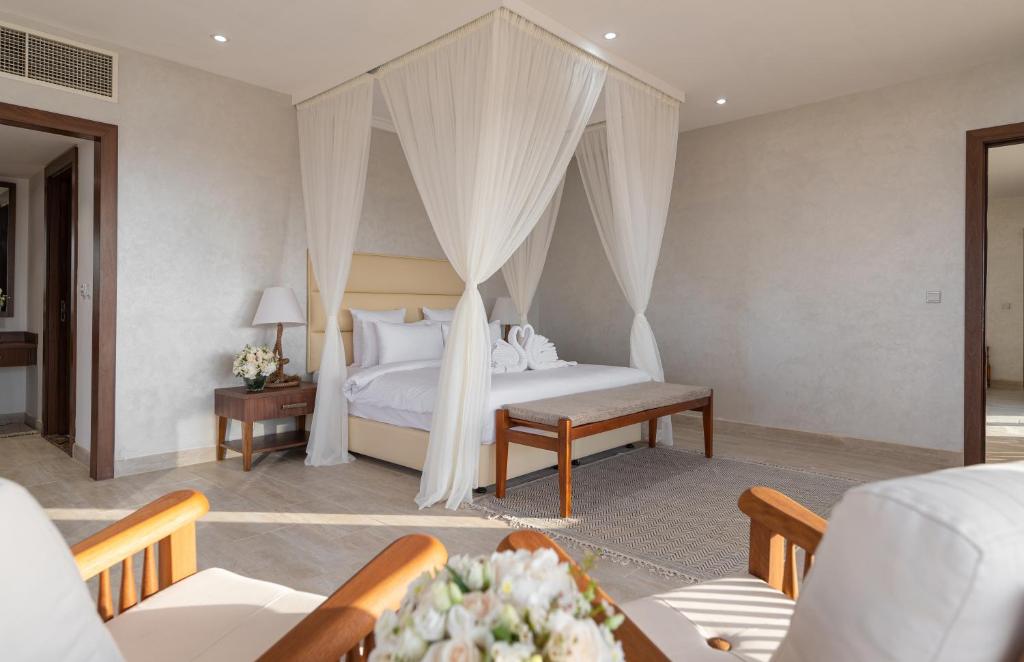 a bedroom with a bed with a canopy at Regency Sealine Camp in Mesaieed