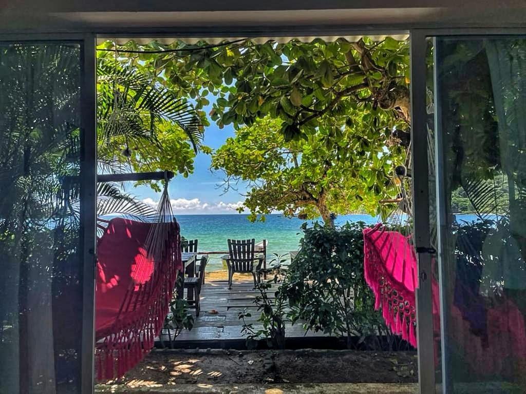 a view of the ocean from the porch of a house at Hostal Hilltop Sapzurro in Sapzurro